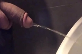 Dotado mijando sem a mão no mictório do banheiro público